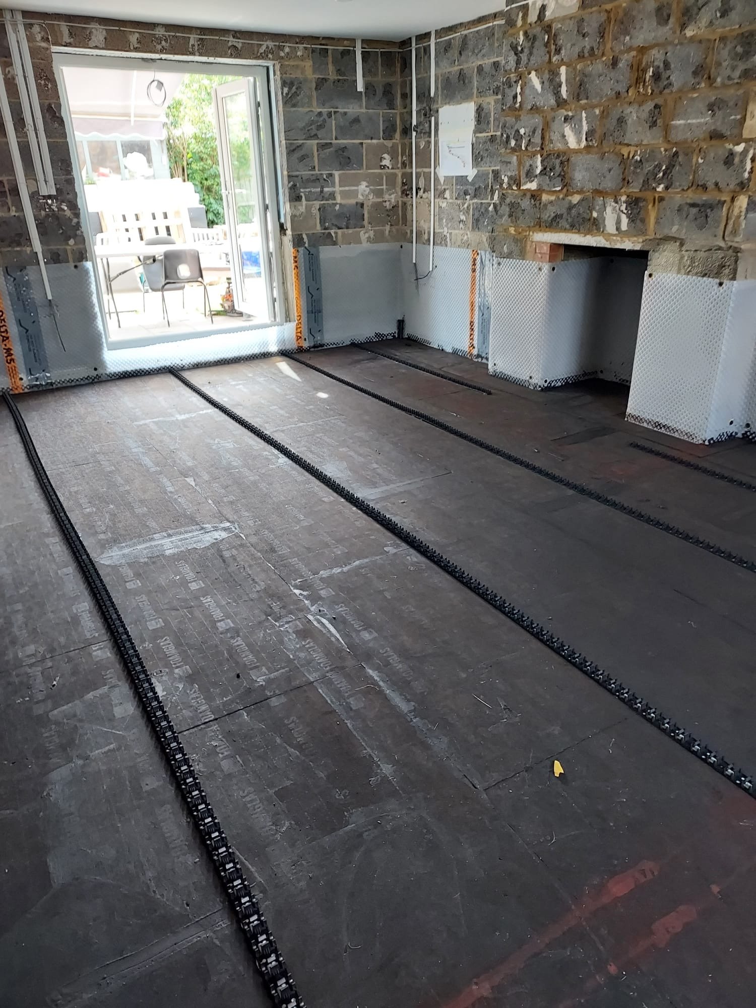 Living room — Foamglas insulation complete, sealed with waterproof bitumen sealant, UFH pipe clips laid ready for the underfloor heating pipes