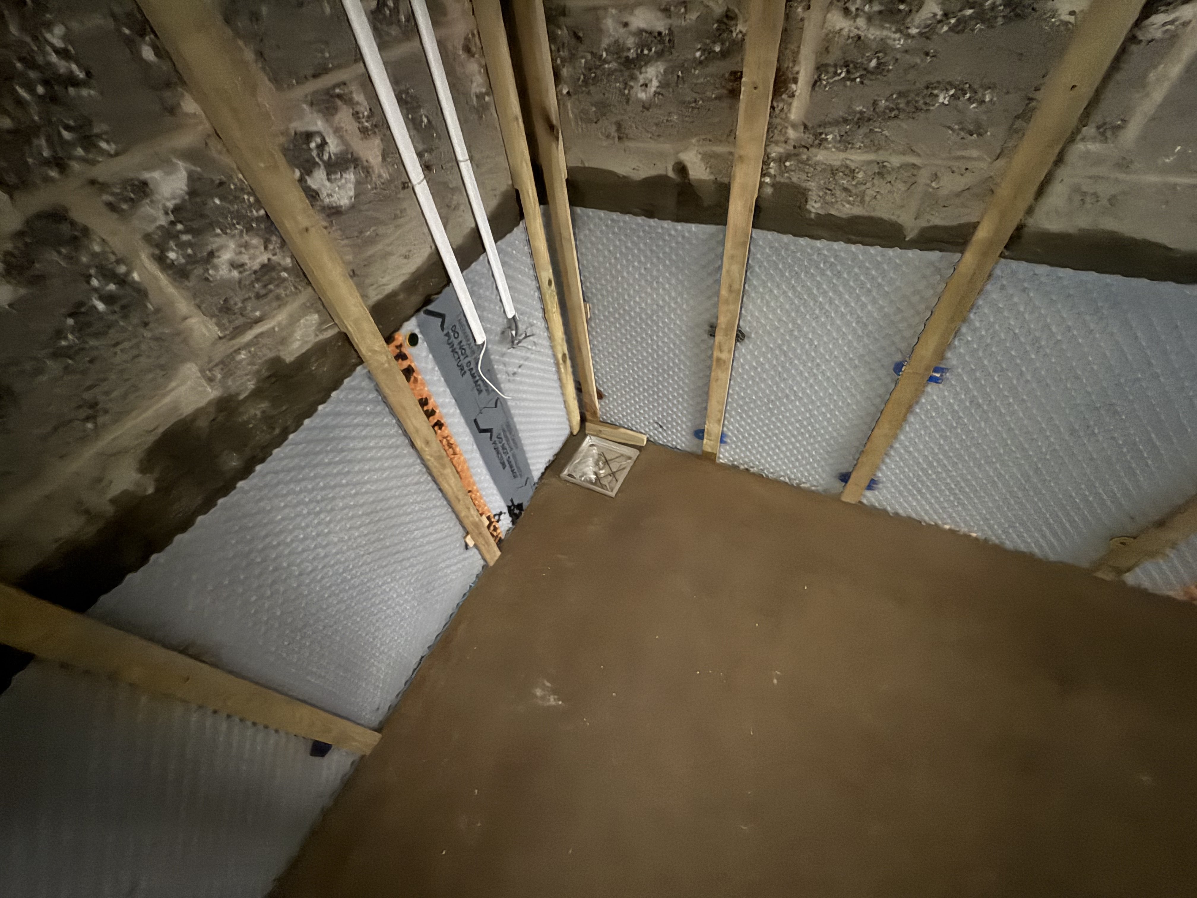 Sump drain access hatch and Delta-MS cavity membrane fixed to battened walls — all tanking complete and ready for plasterboard and Ditra