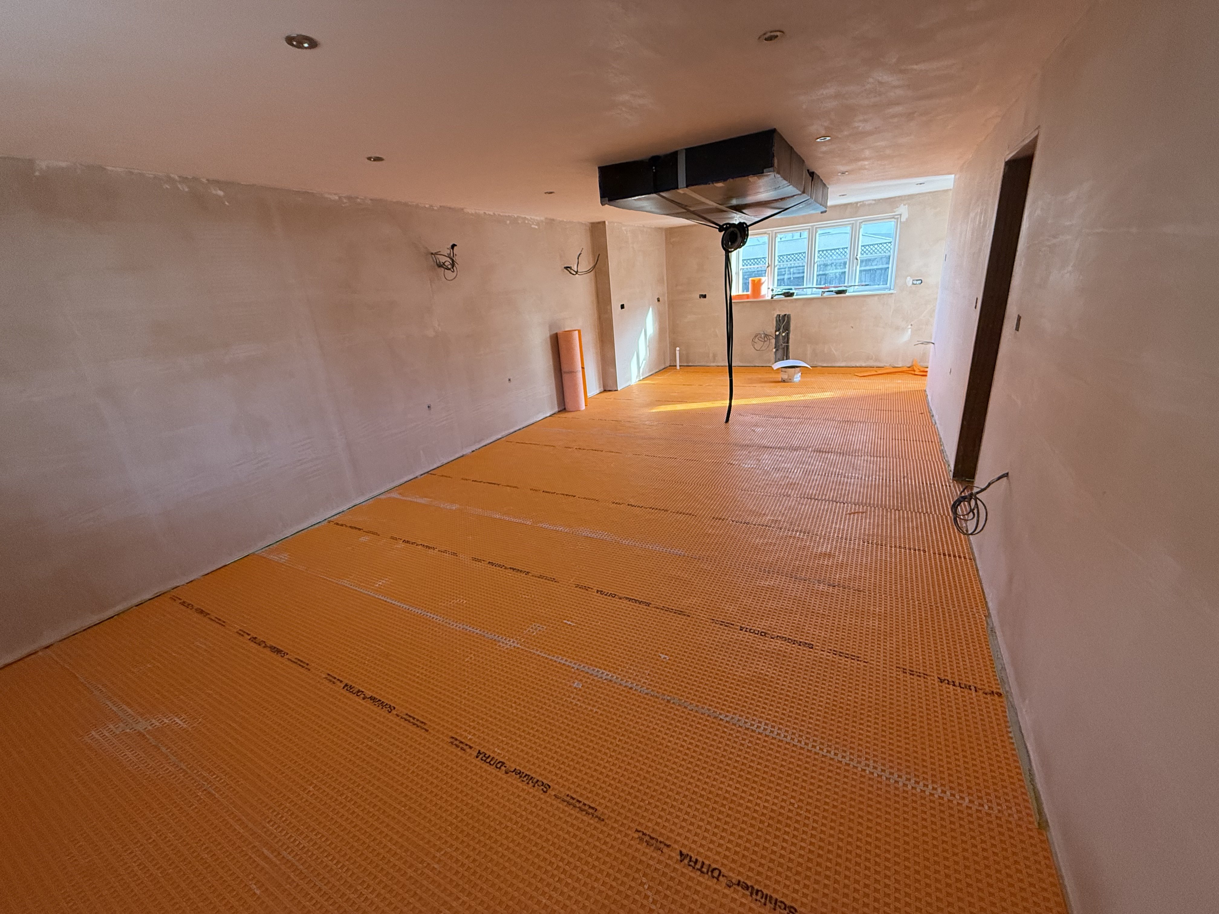Kitchen plastered throughout — Schlüter Ditra uncoupling membrane applied to the floor ready for tiling