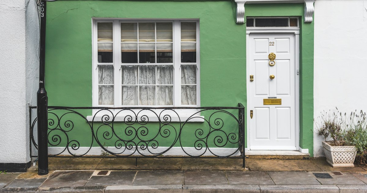 Green-fronted house with a white front door