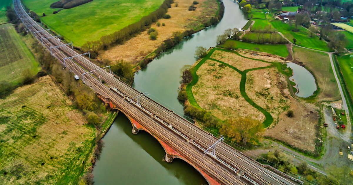 River winding through fields under a bridge, seen from above