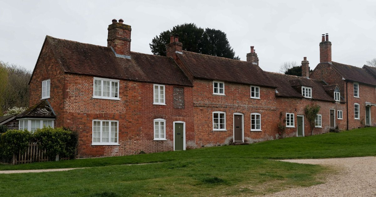 Row of red-brick cottages facing a green