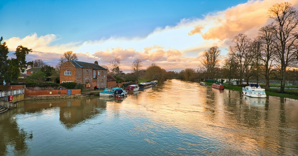 The River Thames running high past a brick building at Wallingford, Oxfordshire